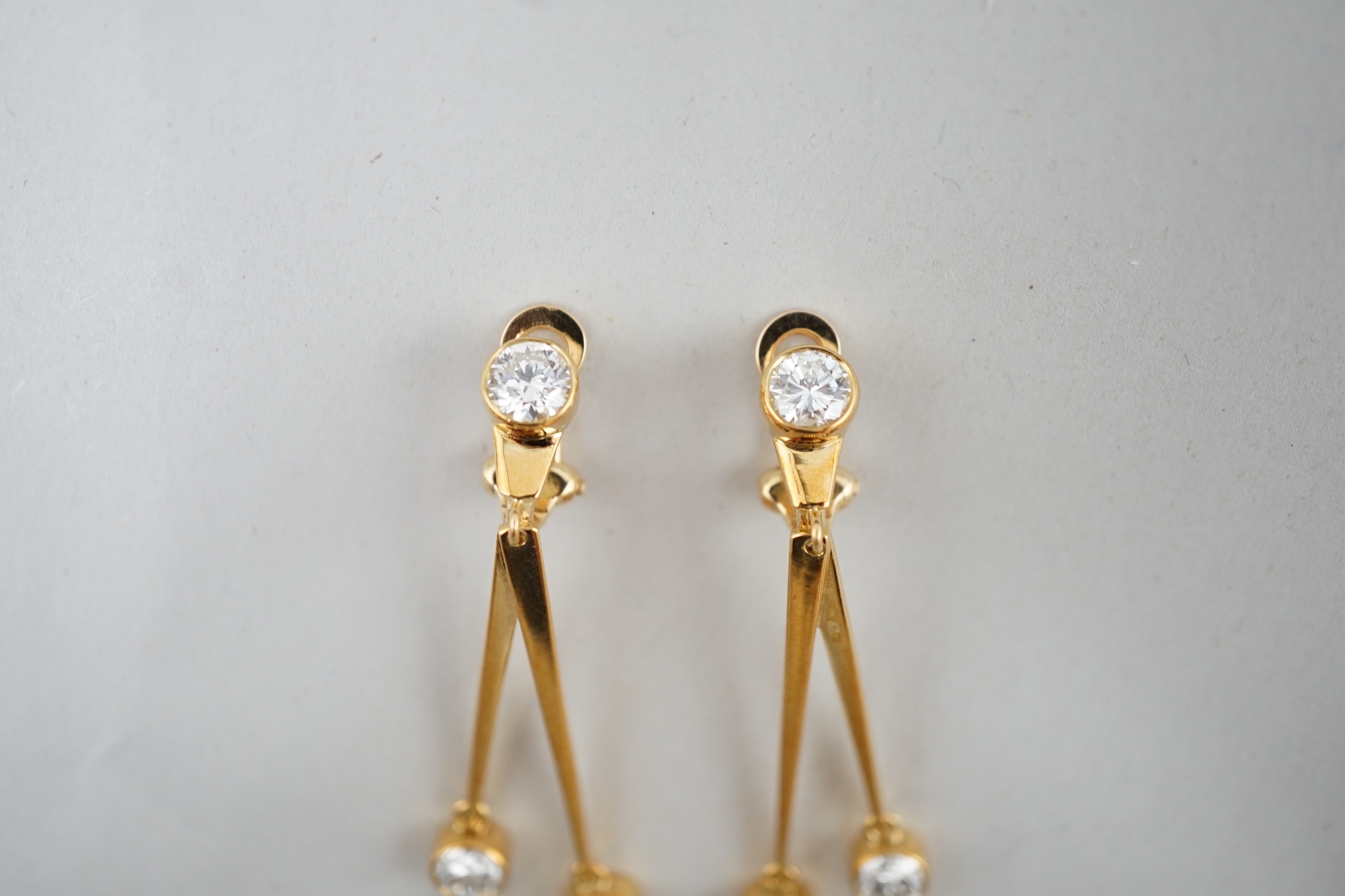 A pair of modern 18ct gold and three stone diamond set double drop ear clips